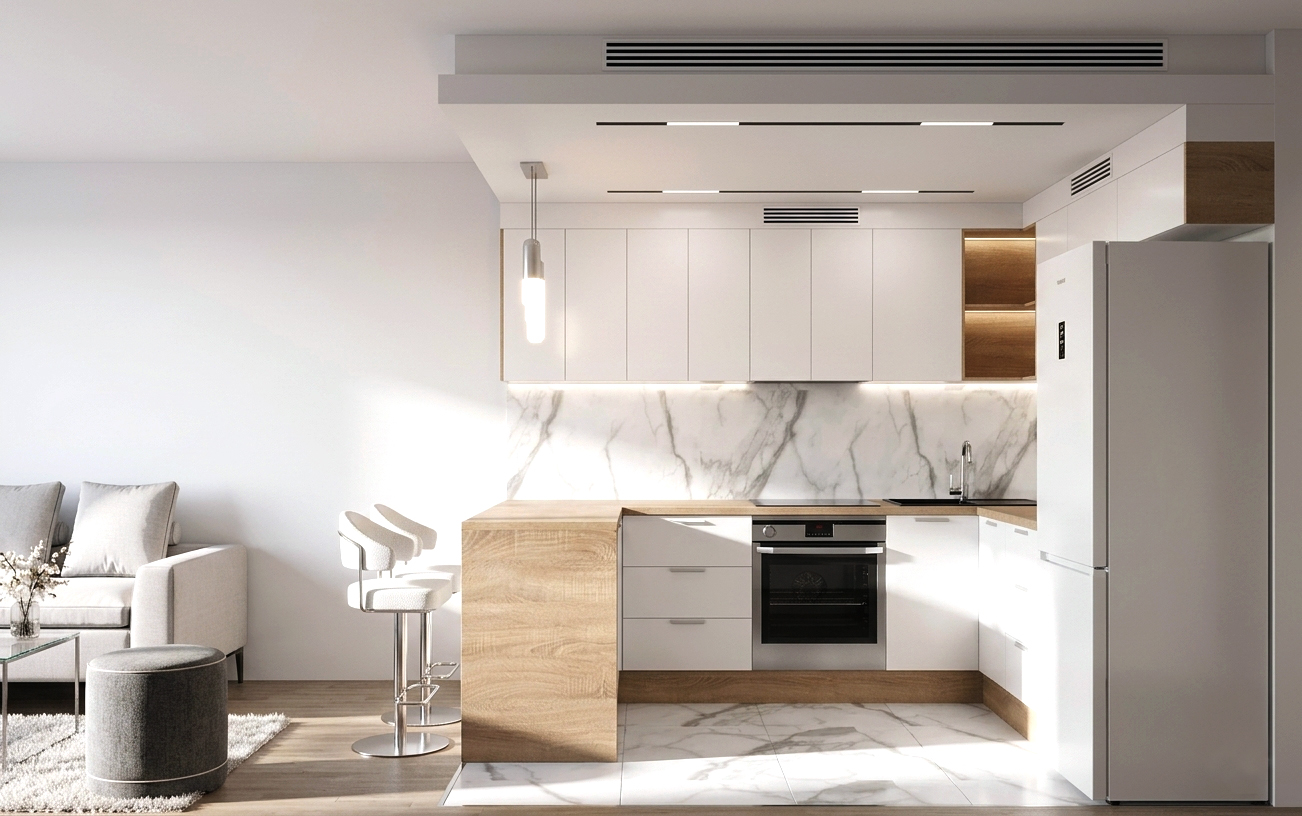 Frontalny widok na białą zabudowę kuchenną pod sufit z wbudowanym piekarnikiem i lodówką oraz marmurowym pasem nad blatem.